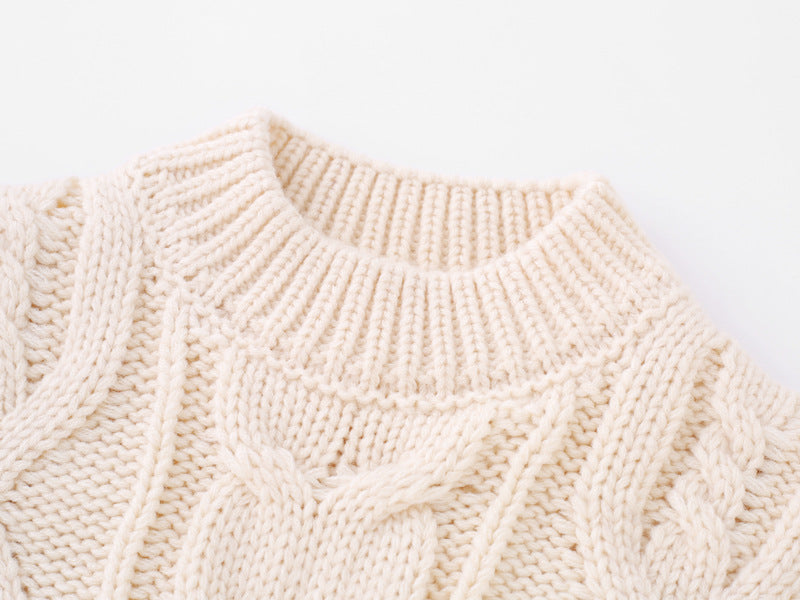 Close-up of a cream cable-knit sweater, part of a matching family set for the holiday season