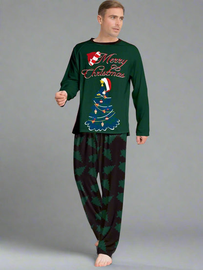 Parents and kids in coordinated green Christmas pajamas with Christmas tree and holiday decor