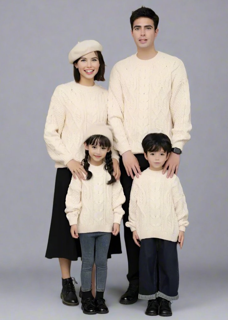 Family wearing matching cream cable-knit sweaters, posing in a cozy indoor setting with elegant and timeless winter fashion