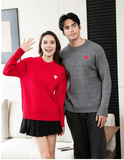 Family of four wearing matching cable knit sweaters in red and white with heart patches, styled for coordinated family outfits