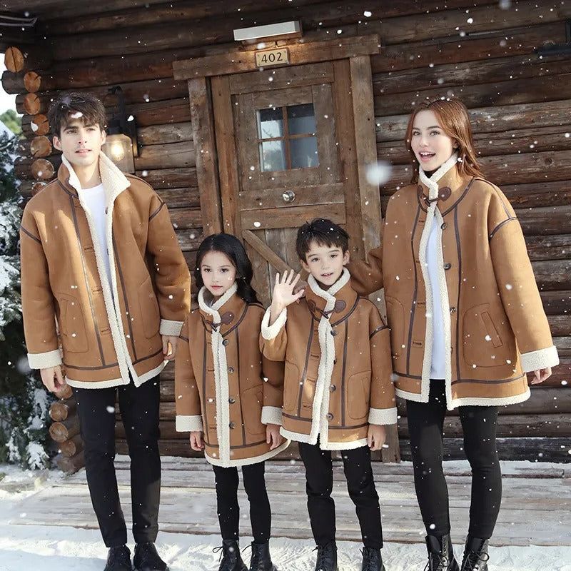 Parents and children in cozy matching brown and cream shearling coats, smiling in a snowy winter cabin setting