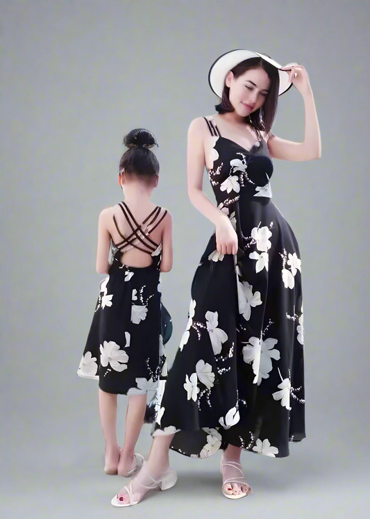 Mother and daughter in matching black floral dresses on vacation