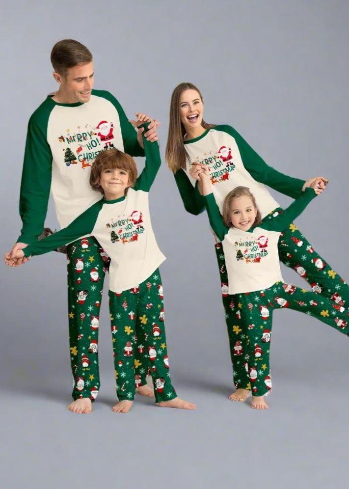 Family in matching Christmas pajamas with Santa design and green holiday print pants