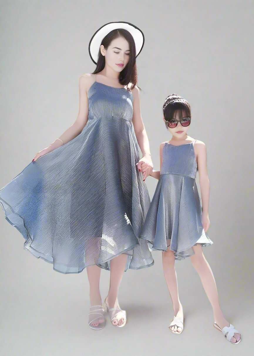 Mother and daughter in matching metallic silver dresses for a summer vacation