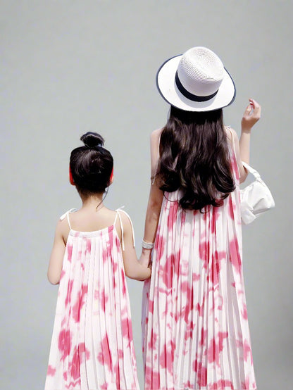 Matching pink tie-dye dresses for mother and daughter by the water