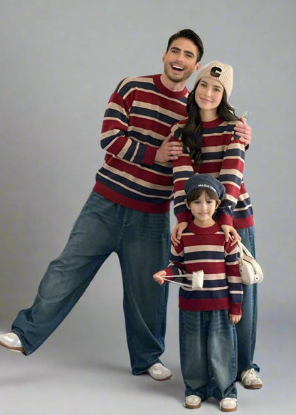 Matching family outfit featuring red, navy, and beige striped sweaters styled with wide-leg jeans