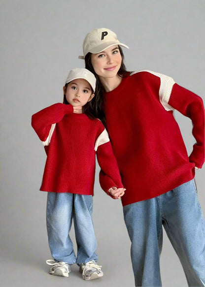 Parents and child in coordinated red sweaters and jeans, a trendy matching outfit for family gatherings