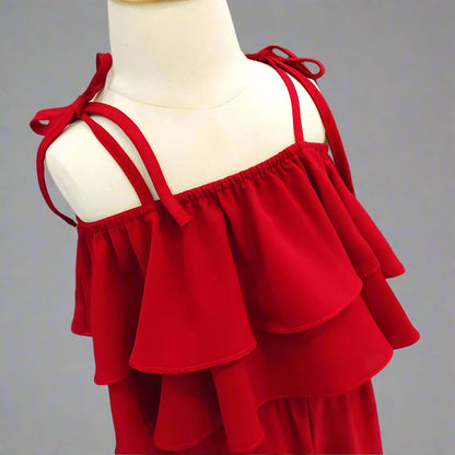 Little girls' red jumpsuit on display, featuring ruffled detailing for a fashionable look